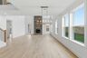 dining room with wood flooring, large light fixture, and a view of the great room