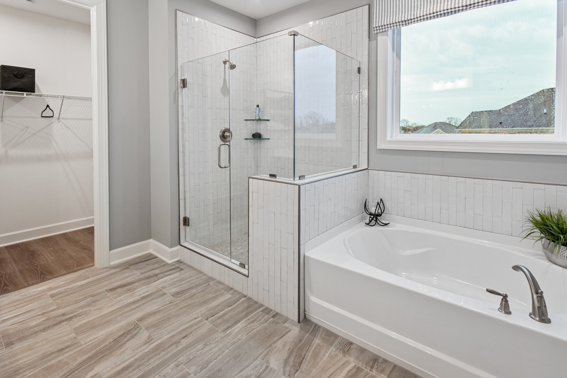 primary bath with walk-in shower, tub, and dual sink vanity