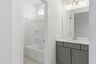 secondary bathroom with gray cabinets, white countertops, and a shower and tub combination