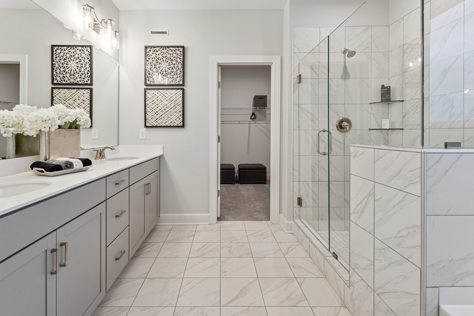 secondary bathroom with gray cabinets, tile floor, and attached closet