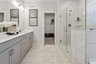 secondary bathroom with gray cabinets, tile floor, and attached closet