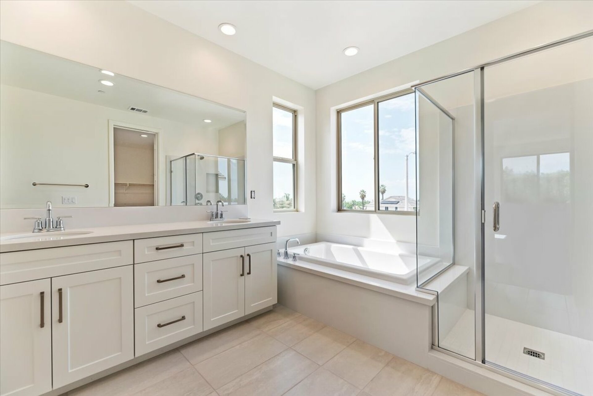 primary bathroom with neutral floors and large windows