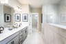 primary bath with gray cabinets and oversized walk-in shower